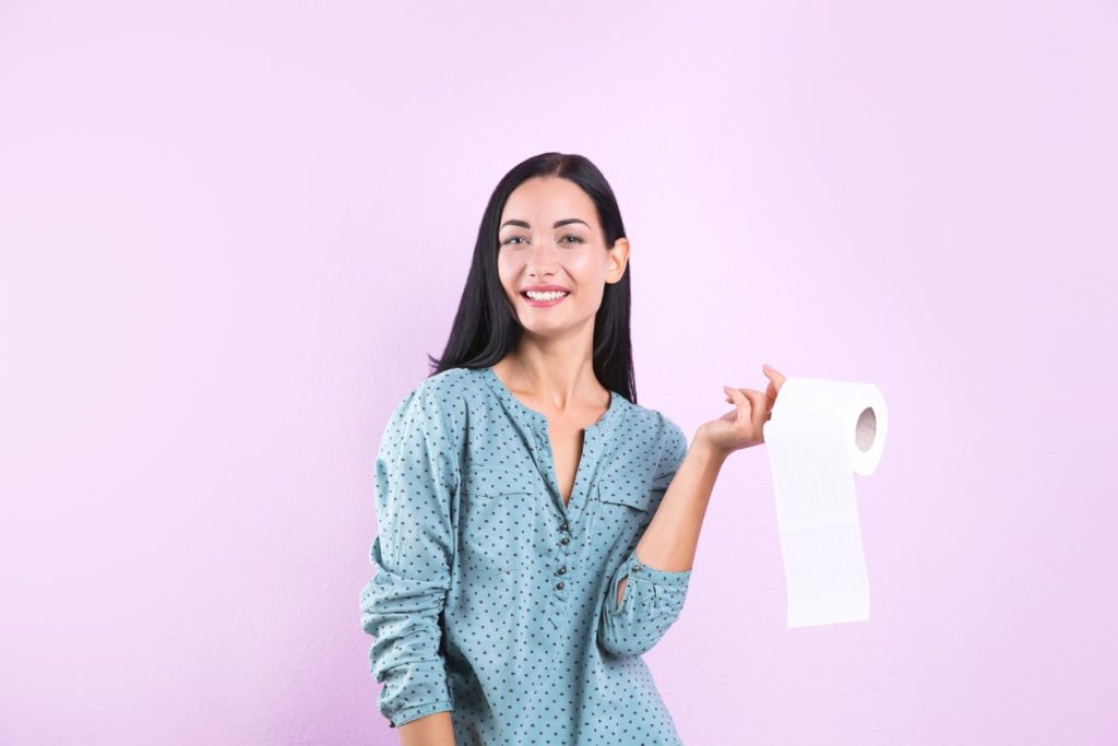 donna con in mano un rotolo di carta igienica