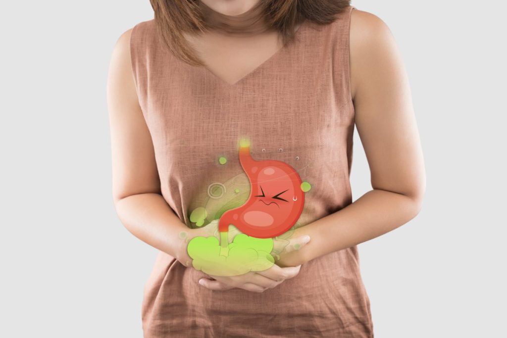 donna che si tiene lo stomaco con disegno che indica gonfiore addominale