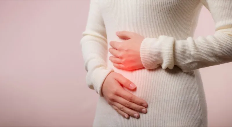 donna che si tiene le mani sull'intestino per la dispepsia