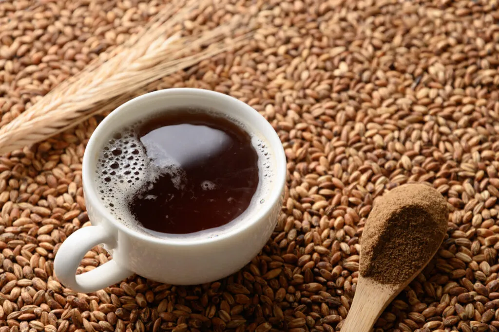 tazzina di caffè d'orzo poggiata su chicchi di caffè