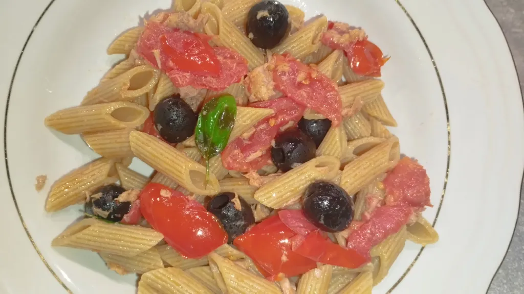 foto di piatto di pasta integrale con olive, pomodori e tonno