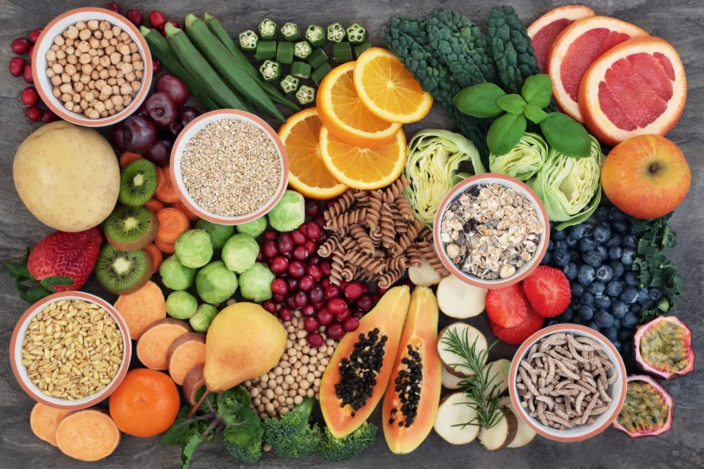 Tavola imbandita di cibi benefici per l'intestino: frutta e verdura fresca, legumi e cereali integrali