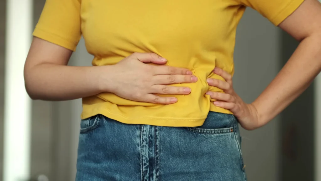 Donna che si tiene la pancia per il dolore