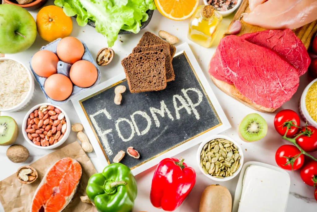Tavola imbandita di cibi con una lavagna al centro con su scritto "Fodmap"