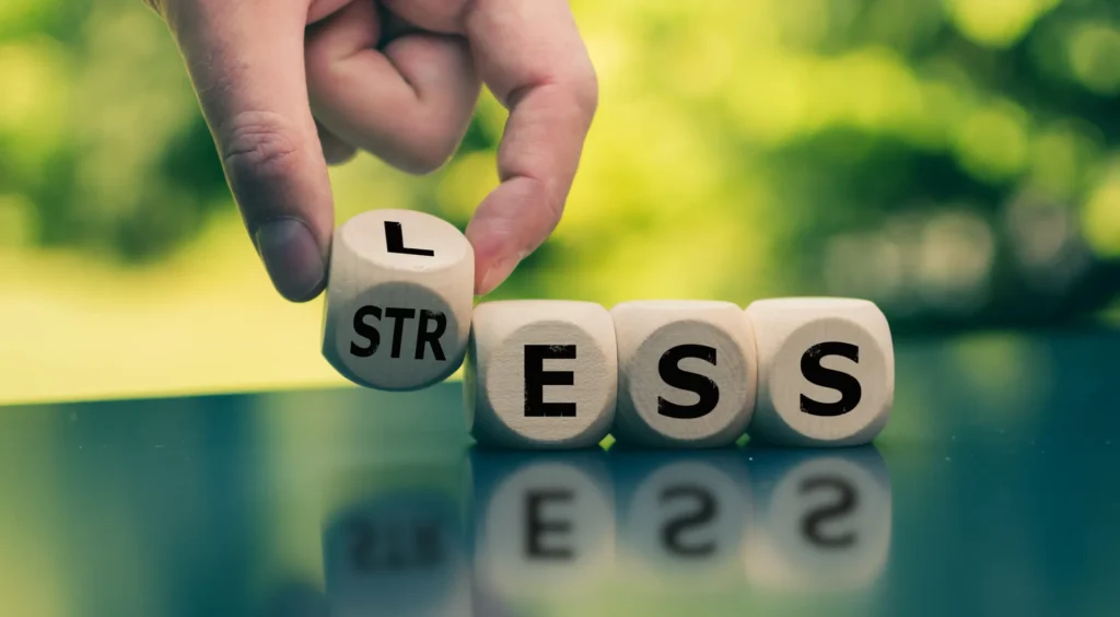 Una mano compone la parola "stress" abbinando dei dadi con le lettere