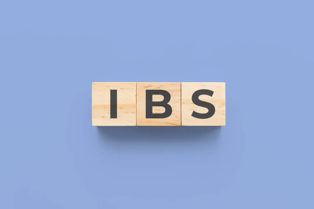 Tre cubetti di legno riportano le lettere “IBS” su sfondo azzurro, acronimo che indica la sindrome dell’intestino irritabile.