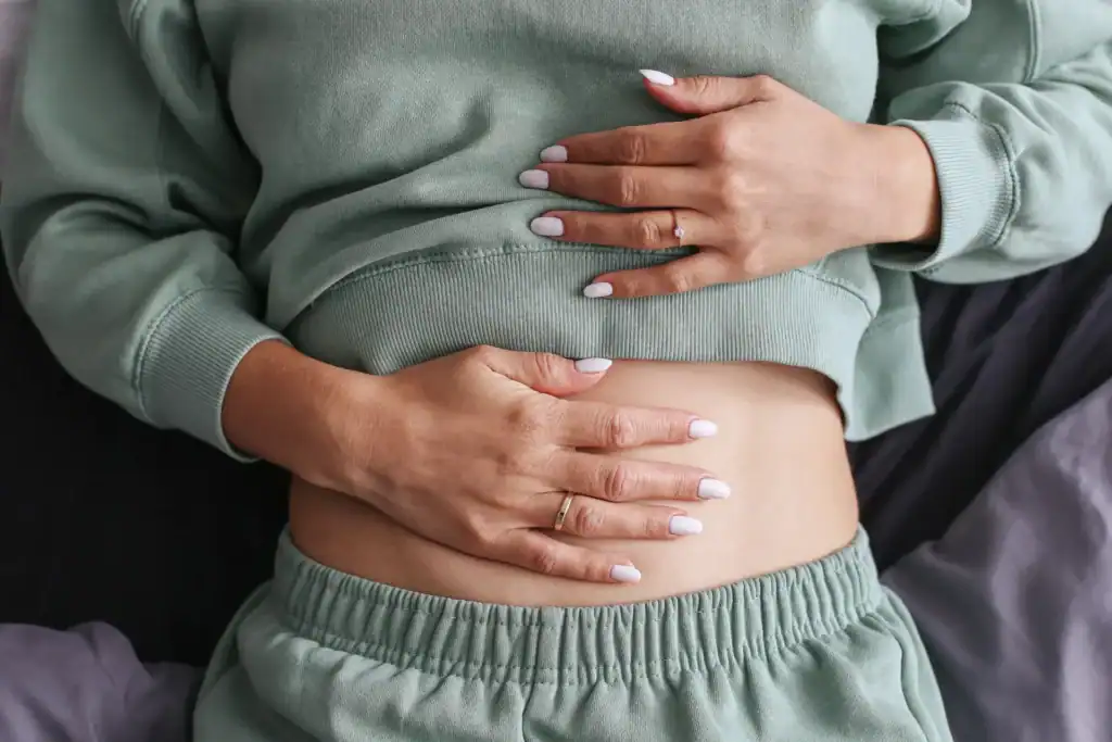 Donna con dolore addominale, segnale di digestione difficile.